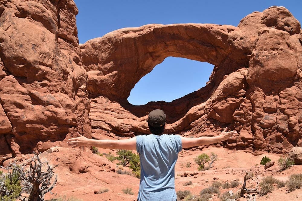 Rober delante de un arco de piedra en el Parque Nacional de Arches